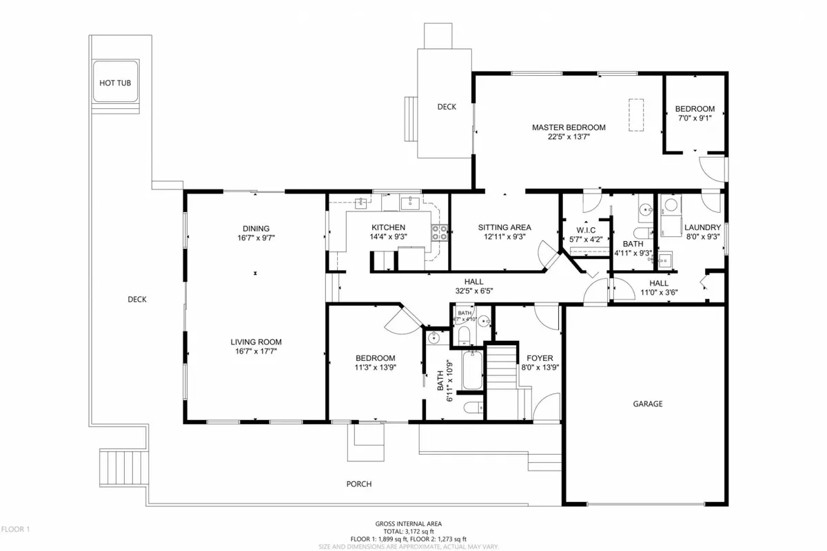 A wide, inviting shot captures the open-concept heart of the home, where the kitchen, dining area, living room, master bedroom, porch, and even a glimpse of the hot tub are visible. The generous kitchen island and dining table are ready for group meals, while plush sofas beckon for relaxation. Large windows provide stunning bay views and bath the space in natural light.