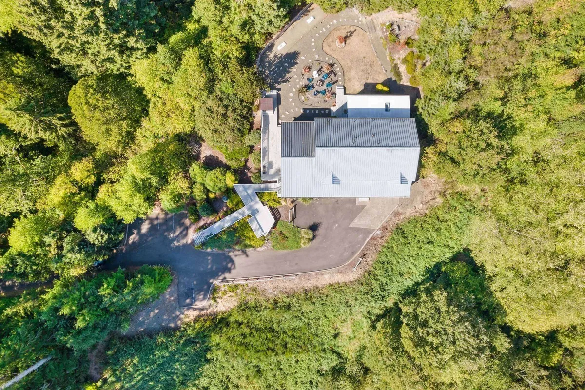 A serene exterior shot of the home, highlighting its landscaped garden and inviting outdoor seating area. The tranquil setting is ideal for enjoying morning coffee or relaxing alongside pets while soaking up the natural surroundings.